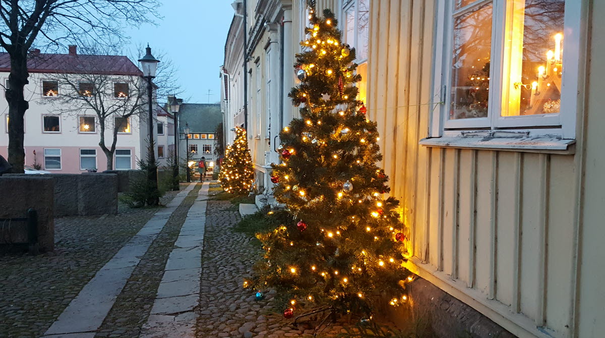 Julpyntade granar vid husfasad i Gamla Stan i Mariestad.