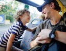 Happy laughing young boy with dad on a bus