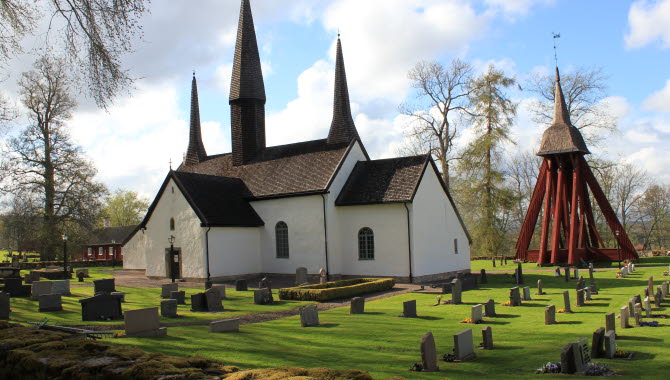 Kungslena kyrka. En vit stenkyrka med röd träklockstapel vid sidan.