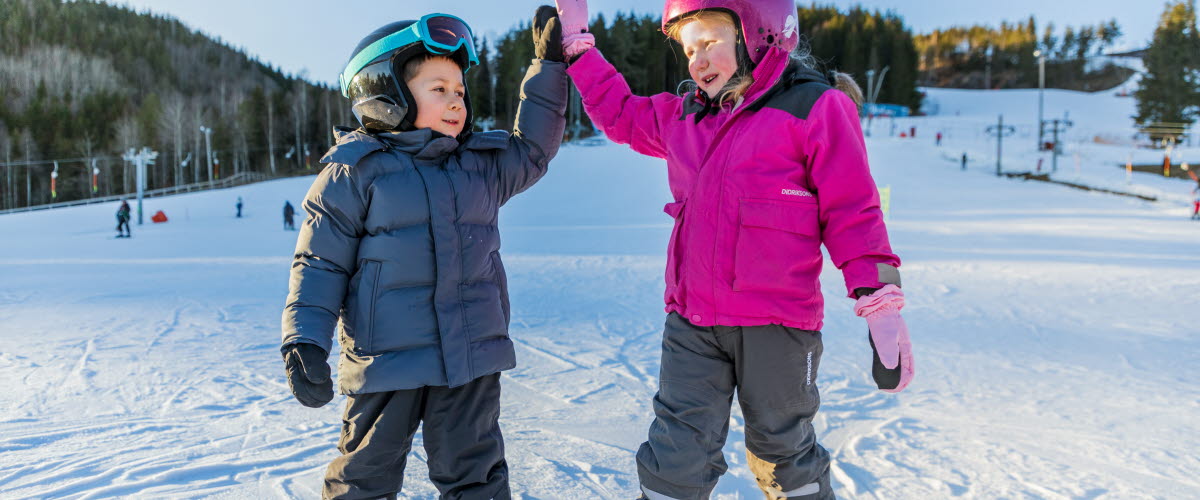 Children high-fiving on a slalom slope