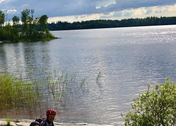 Two persons resting near a lake