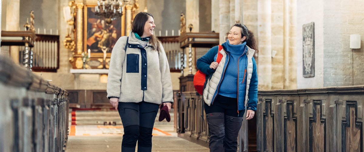 Två kvinnor inne i Varnhems Klosterkyrka.