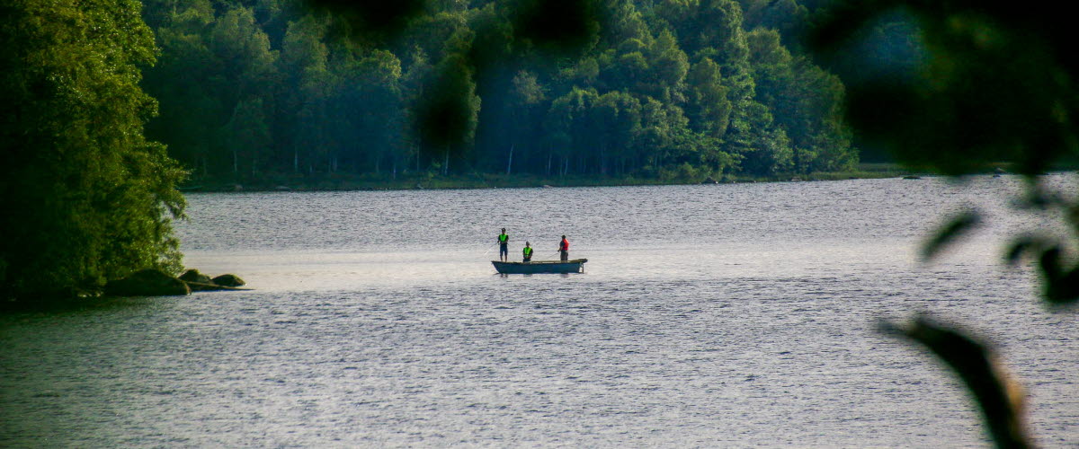 Tre personer i en båt ute på sjön