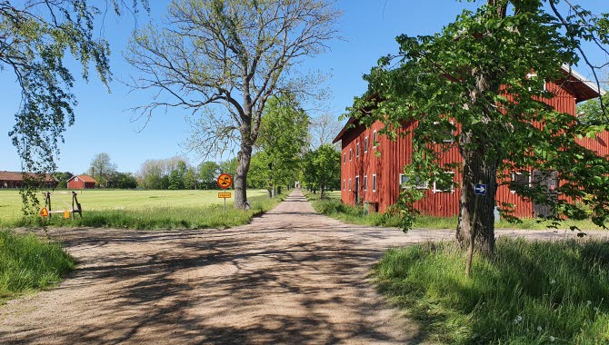 En fyrvägskorsning med ett rött hus på höger sida.