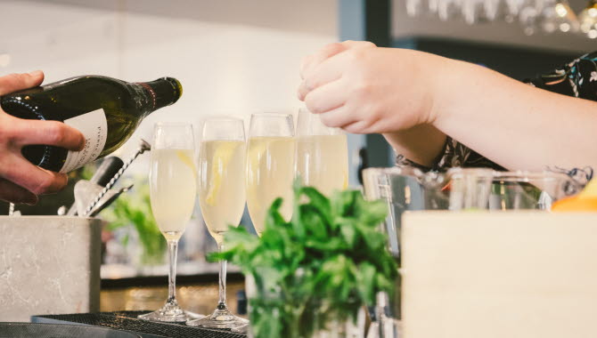 Barpersonal häller upp champagne på Hotel Strana