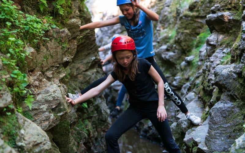 Två barn i hjälm som klättrar