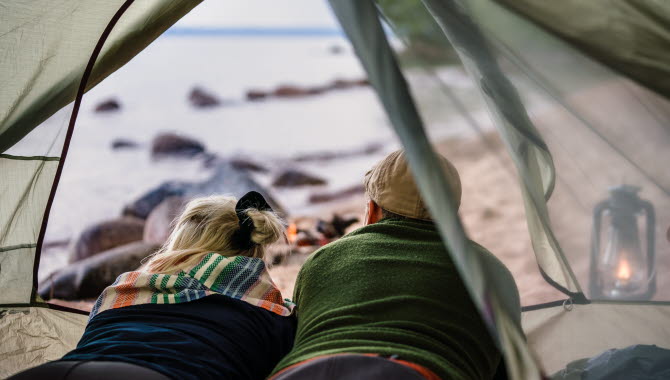 Couple in a tent on a Swedish beach, outside Hjo.