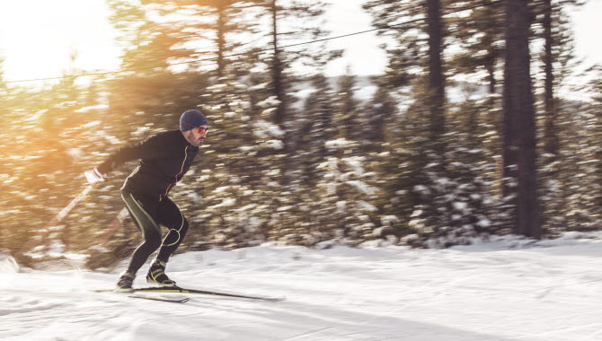 En skidåkare med fart tar sig fram på vit snö