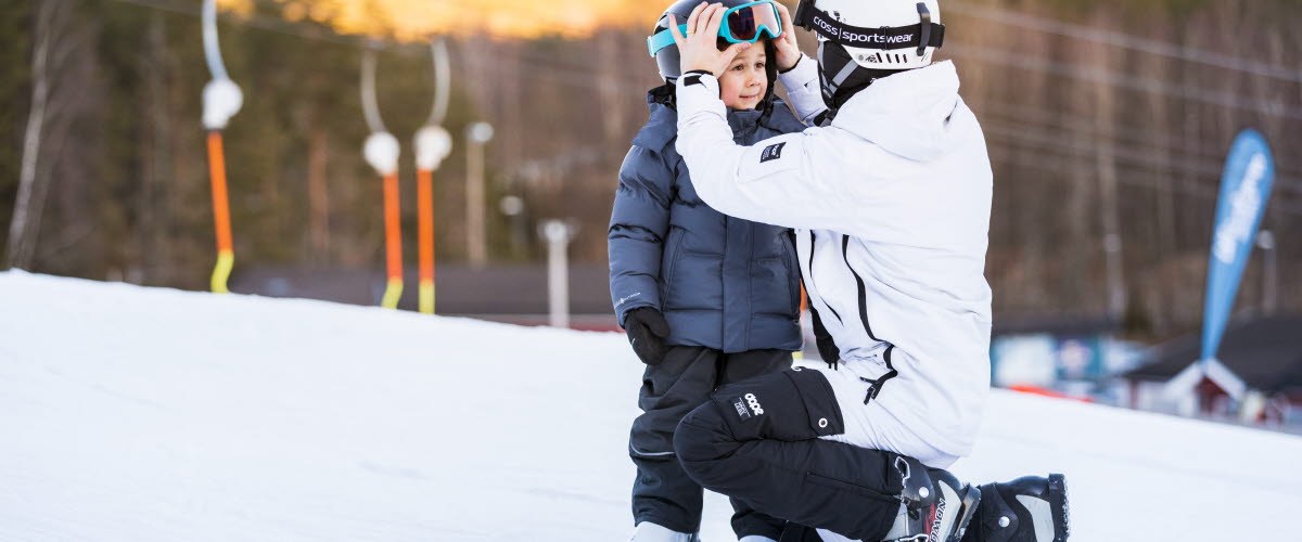 Barn och förälder i slalombacke