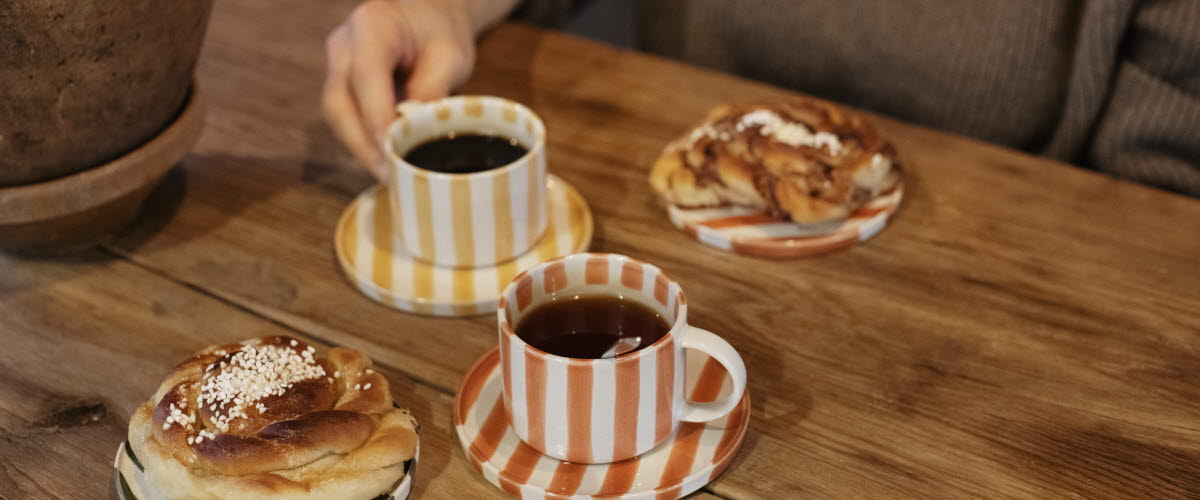 Kvinna håller i en kopp på ett kafé.