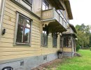 Yellow large wooden building with porch.