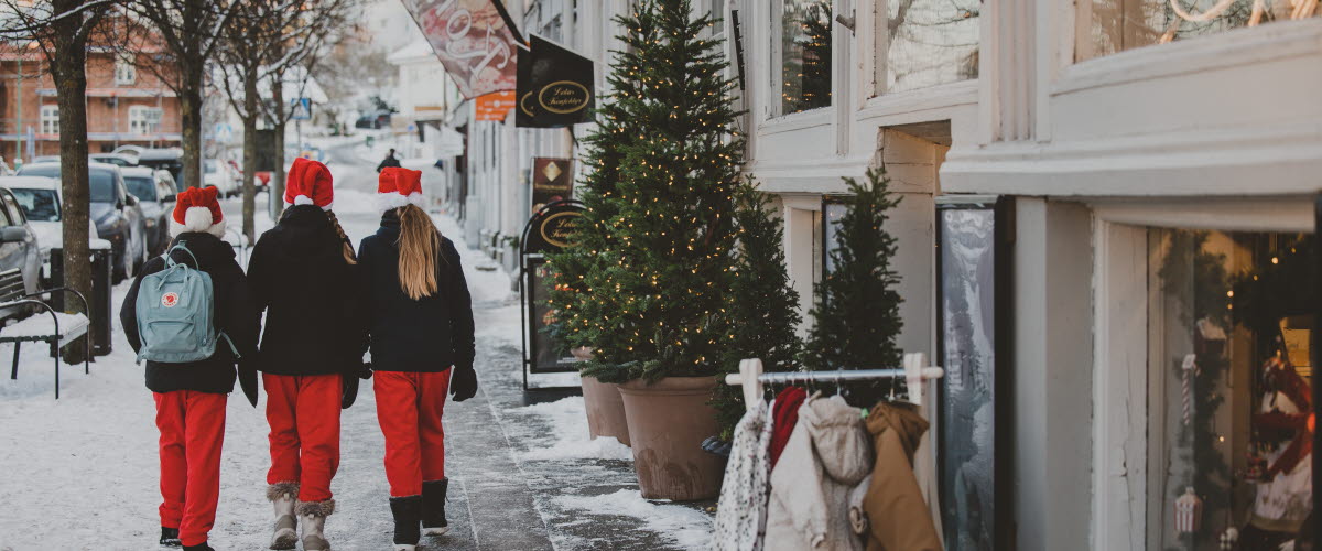 Tre jultomteklädda barn promenerar i Strömstad stad