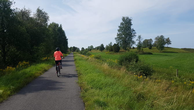Tjej i orange tröja som cyklar på Ätradalsleden.