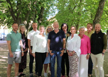 Foto på flera personer som står i en park