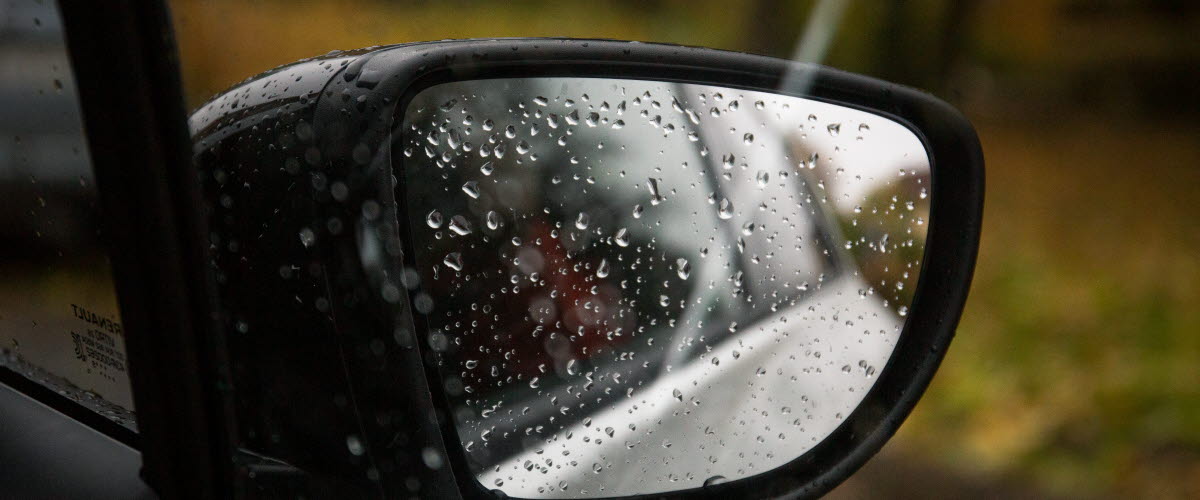 Backspegel på bil en regnig dag.
