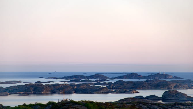 Rosa skymningsljus över Kosterarkipelagen med Ursholmen fyrplats i bakgrunden. Bilden är tagen från Valfjäll, Sydkoster.
