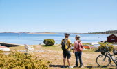 Two people are cycling on an island.