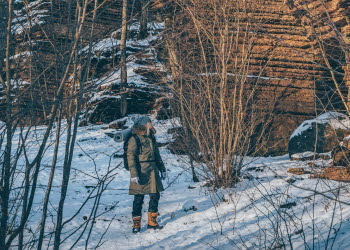 En kvinna som går omkring bland stenformationer i ett vintrigt landskap
