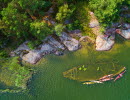 A wreck lying near land in the water. It can be seen from above.
