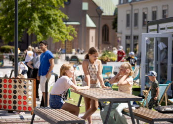 Tre tjejer hänger vid ett bord på Sommartorg . 