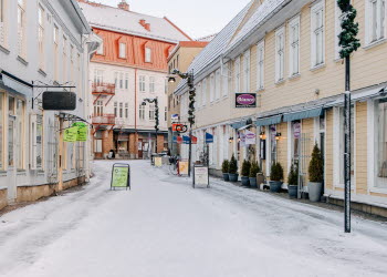 En vintrig gata i stadsmiljö kantad av ljusgula hus.
