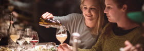 Woman is filling a glass at a set table