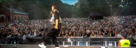 An artist standing on stage in front of a crowd of people