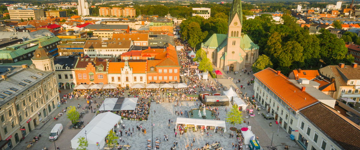 Drönarbild över Hertig Johans Torg i Skövde Centrum under Matfestivalen 2019. Vacker stadsvy med blå himmel och eftermiddagssol som gör sig redo att gå ner. 