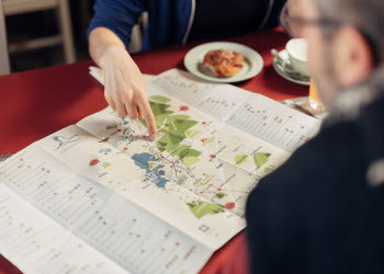 Två människor planerar sin vandring över en fika.