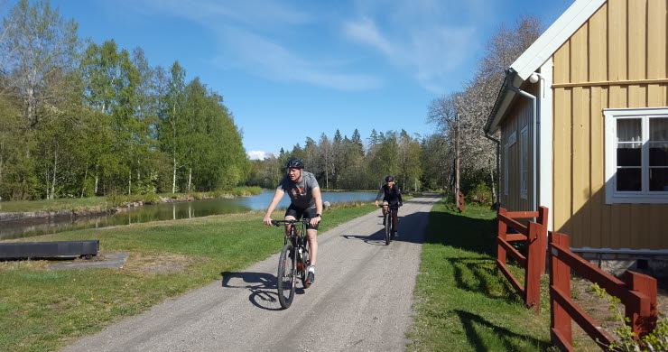 Två personer cyklar längs Göta kanal nära Sjötorp.