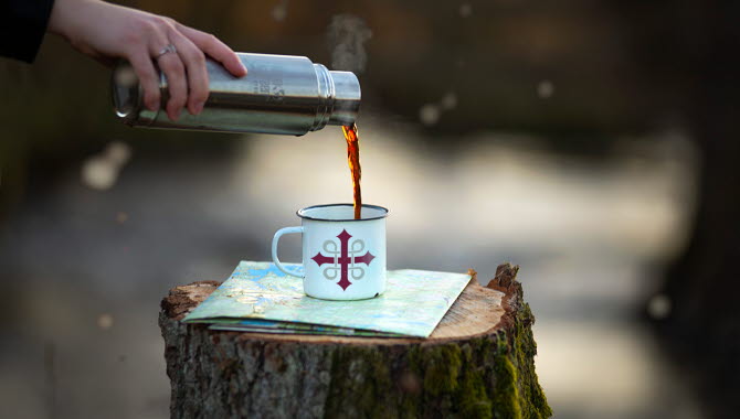 Termos med kaffe och en mugg med pilgrimsmärket.