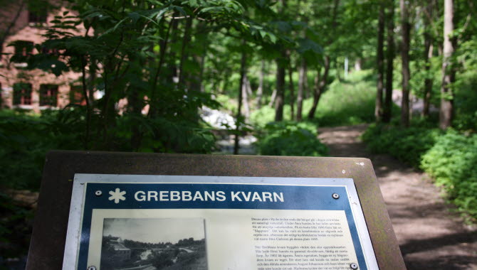 Skylt om Grebbans Kvarn i naturreservatet Hjoåns dalgång.