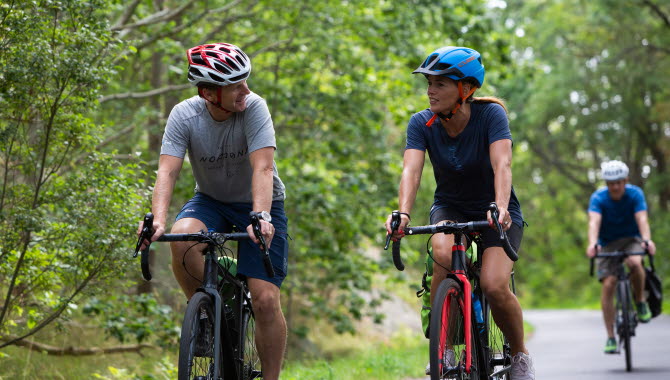 Two cyclists talking during a bike ride.