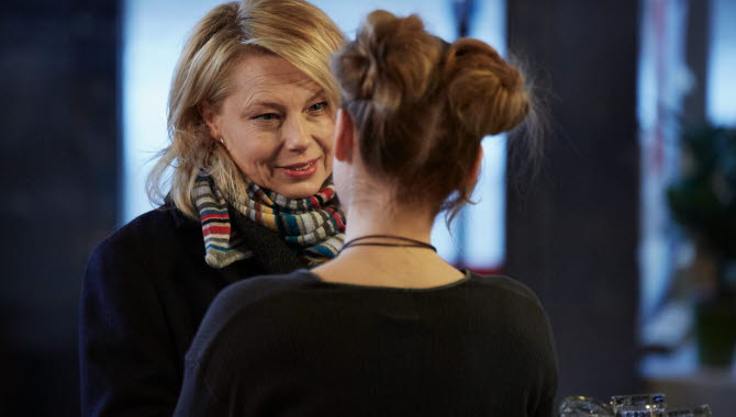 Blond kvinna tittar på en annan kvinna mittemot
