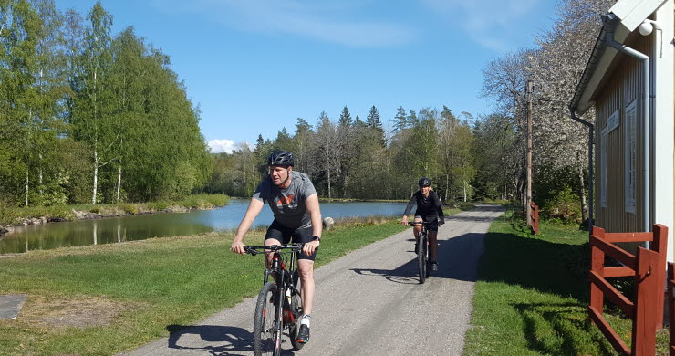 Två personer cyklar längs Göta kanal nära Sjötorp.