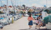 Barnfamilj promenerar ute på Torskholmen, Strömstads fiskehamn. 