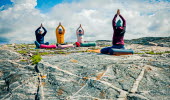 En grupp människor som gör yoga utomhus på kusten.