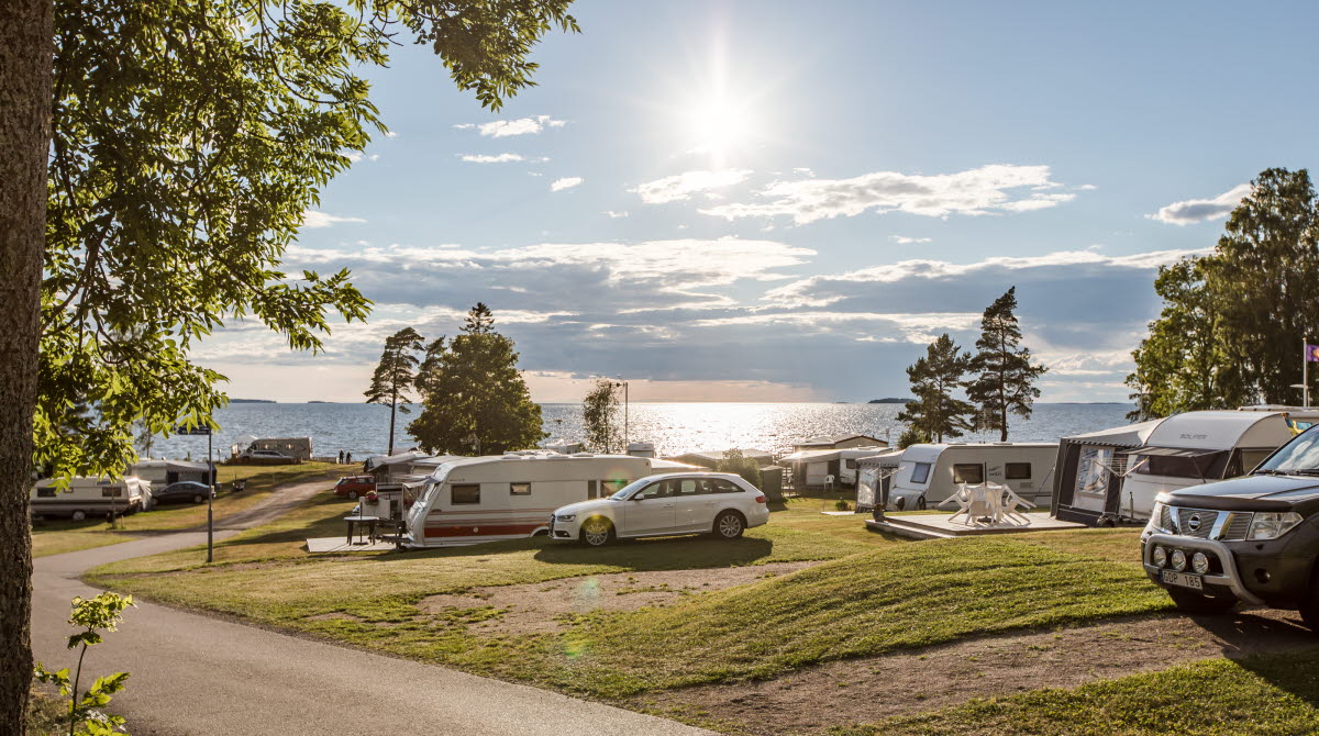 Vy över Askeviks camping med husvagnar och bilar, Vänern i bakgrunden.