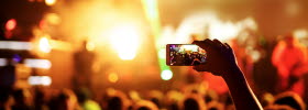 Hand with a smartphone records live music festival, live concert, show on stage