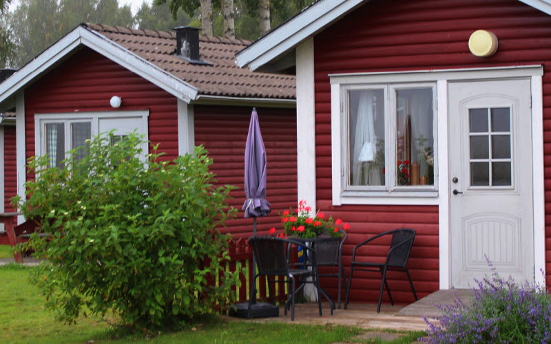 en röd stuga på en gräsmatta
