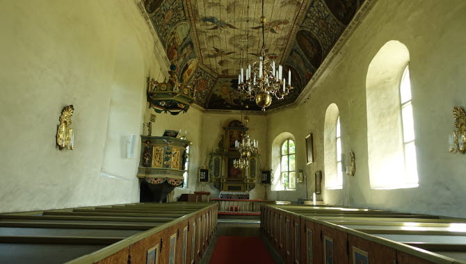 Insidan av Flistad kyrka med vacker målning i taket.