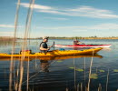 Two people are kayaking on a lake.