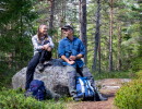 Två personer sitter på en sten i skogen.