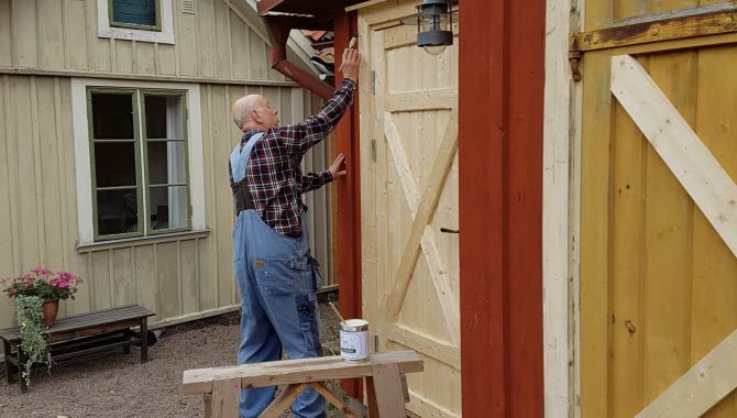 Man målar sitt hus i de gamla delarna av Hjo.