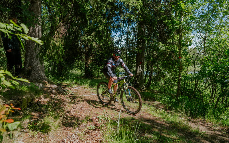 En cyklist cyklar på en stig i skogen