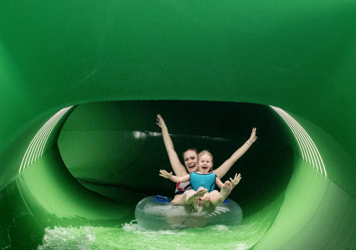 Woman with child goes swimming in the water slide