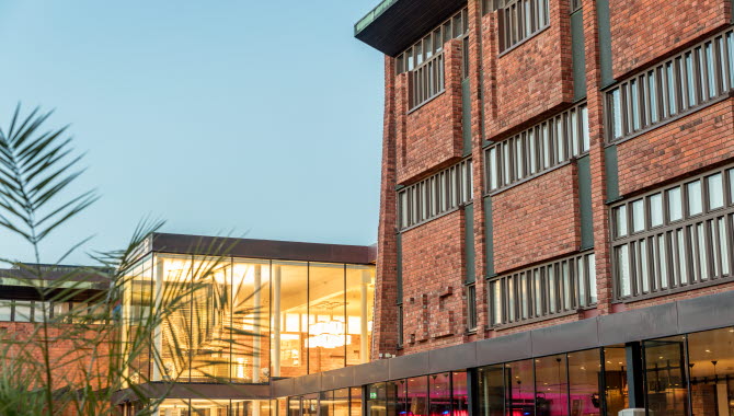 Skövde Kulturhus, ett hus i rött tegel med många fönster och flera reliefer.