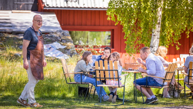 En familj fikar i trädgården