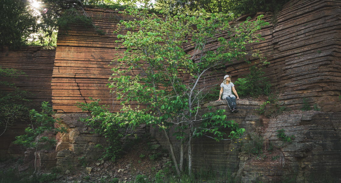 A women enjoys the beauty of an abandon quarry in Platåbergens Geopark