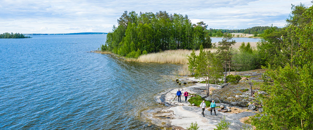 Fyra personer vandrar på klippor vid Vänern, på vandringsleden Ekudden-Sandviken i Mariestad.